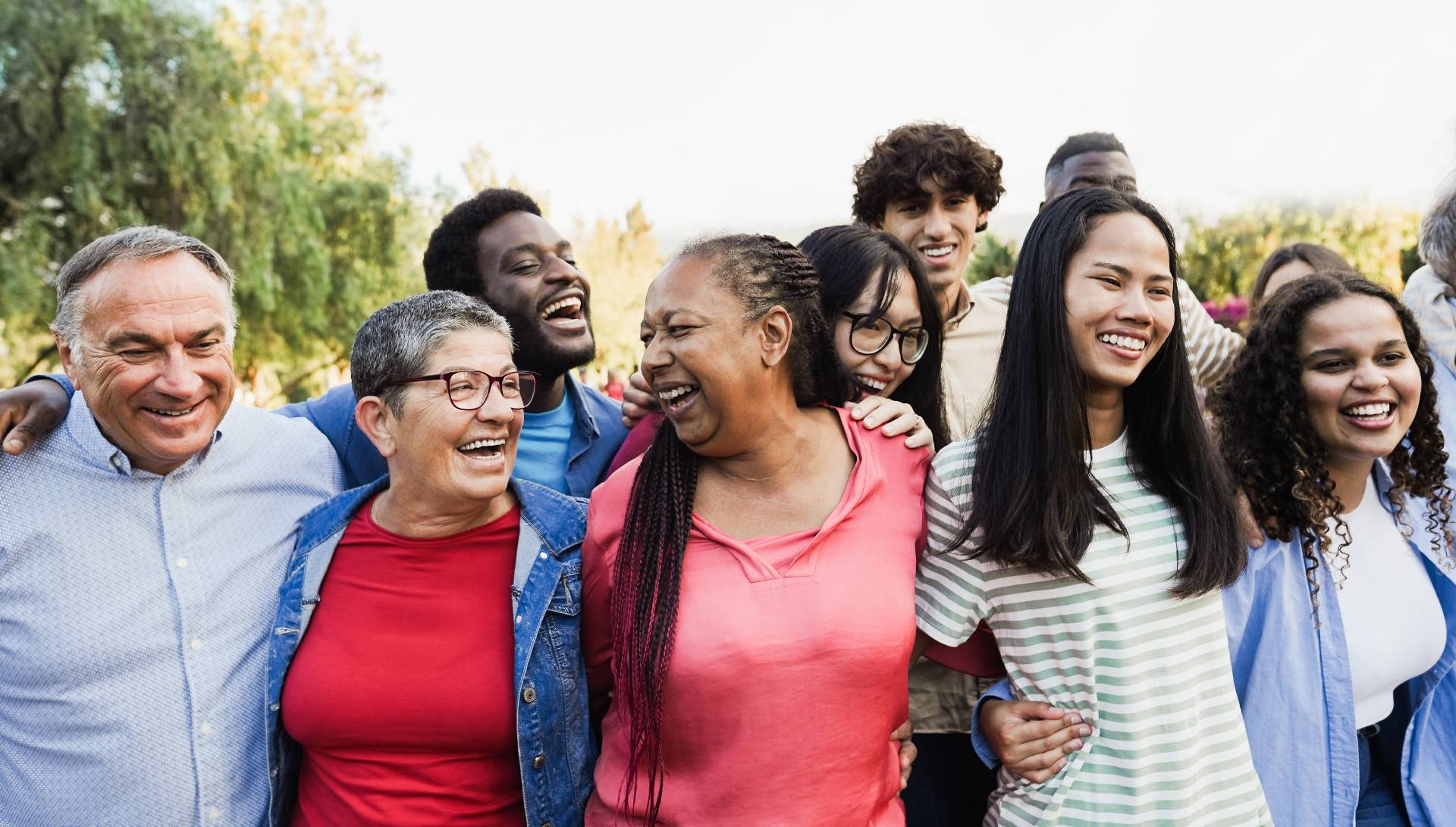 A diverse group of friends smiling and enjoying time together outdoors.