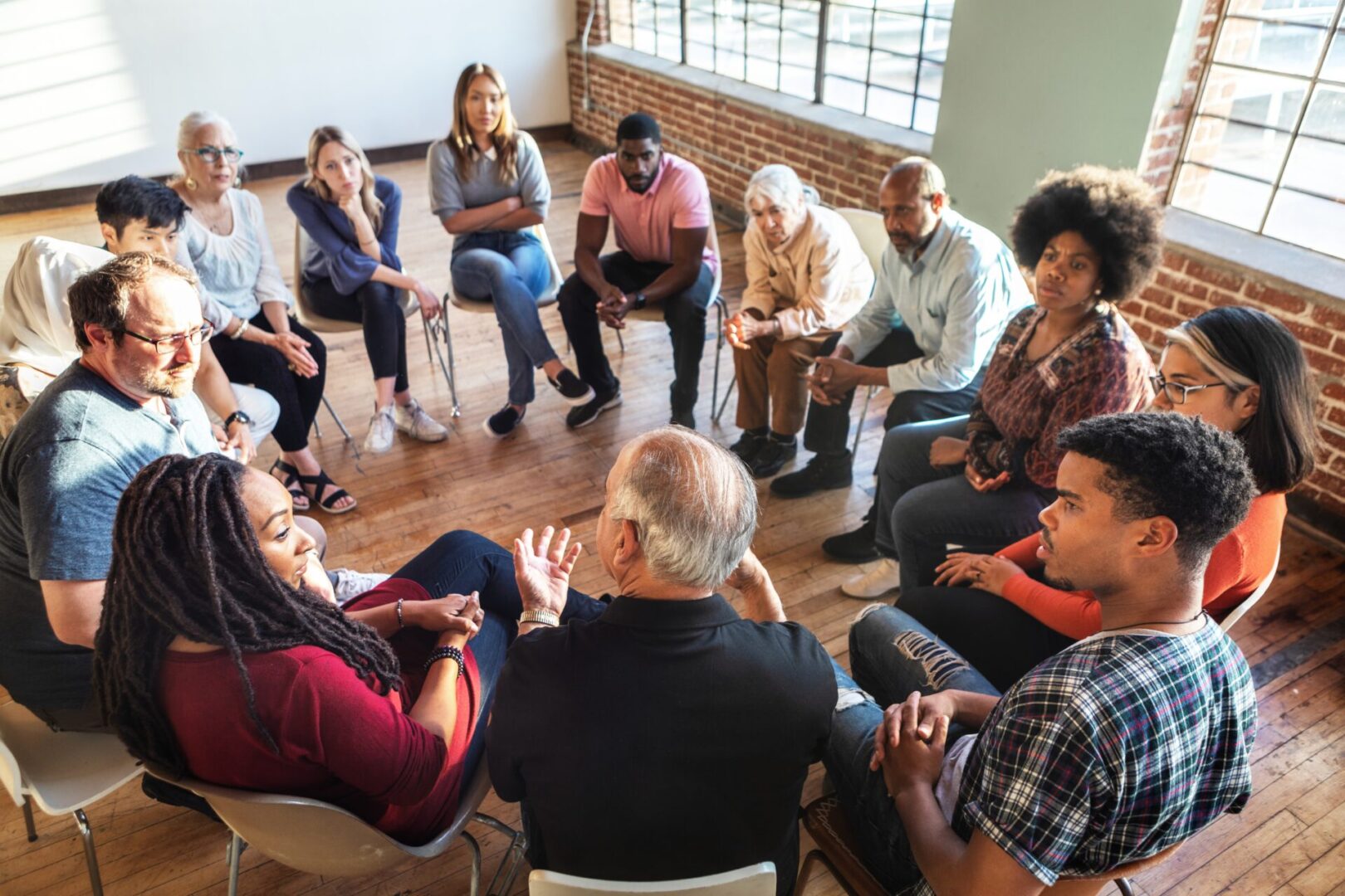 A diverse group engaged in a supportive group discussion.