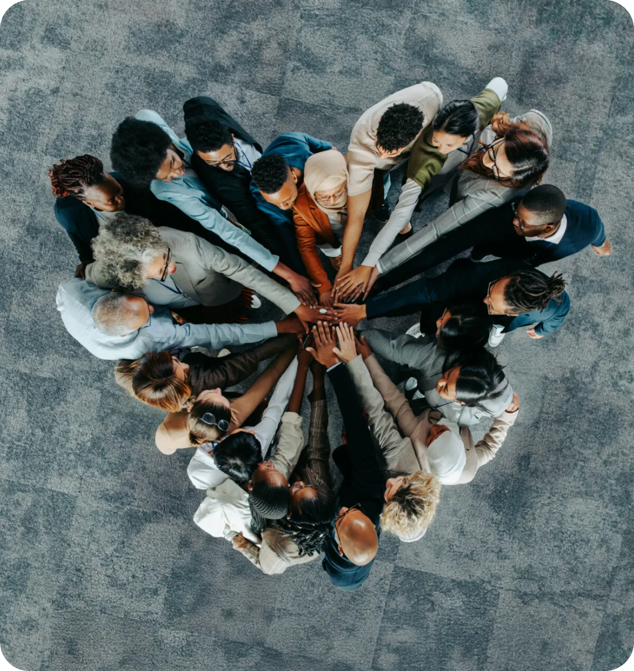 Team members join hands in a circle, symbolizing unity and collaboration.