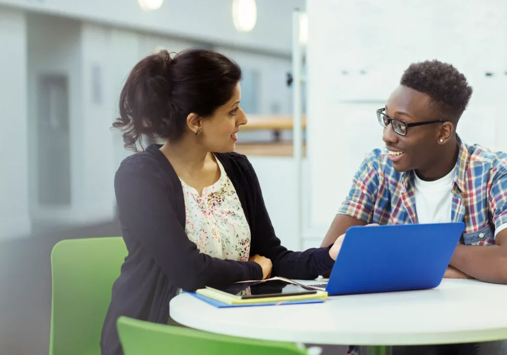 Two colleagues discussing work in an office setting.